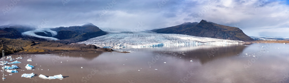 Obraz premium Panorama of Fjallsarlon glacier lagoon, Southern Iceland. Part of the Vatnajokull Glacier, the largest ice cap in iceland. Wide panoramic drone shot
