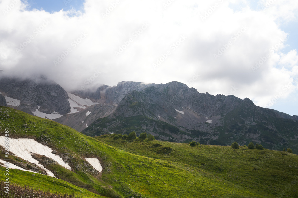 Obraz premium alpine meadows in the mountains with clouds on a sunny day