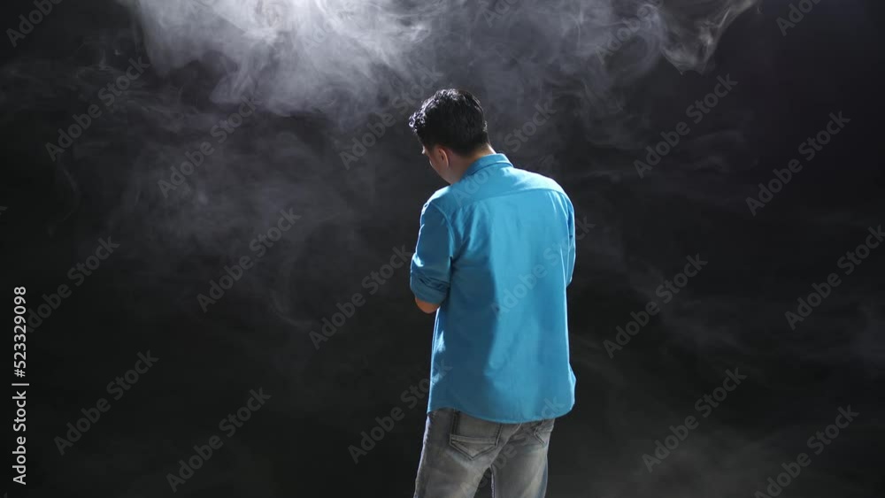 Back View Of A Man Holding A Microphone And Rapping On The White Smoke Black Background
Back View Of A Man Holding A Microphone And Rapping On The White Smoke Black Background
