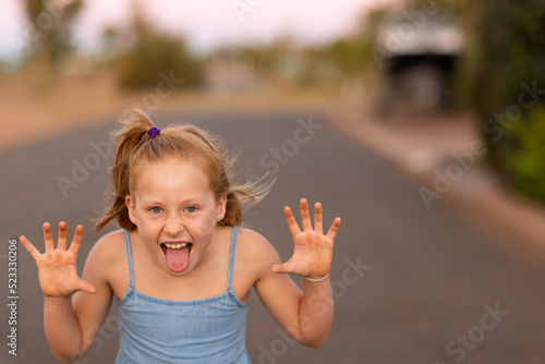 girl outside making scary face with hands like claws photo