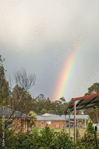 End of a rainbow over houses