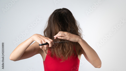 A woman with scissors cuts her own hair - weak and naughty, problematic hair,