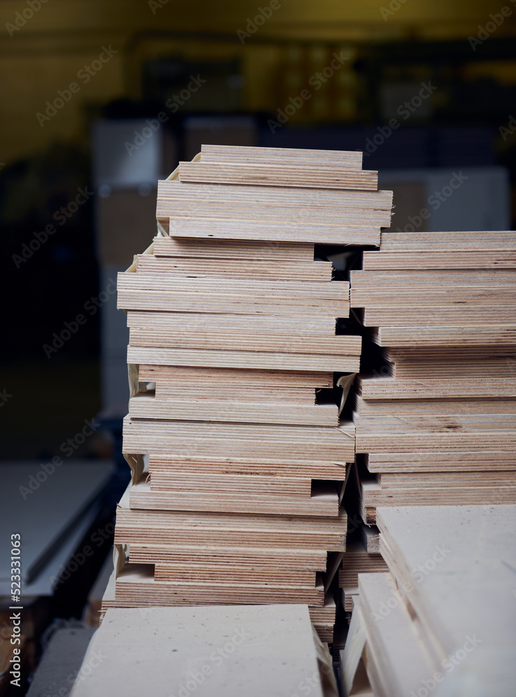 Sheets of laminated waterproofed industrial plywood in a factory setting. Joinery and carpentry workers materials. Glued and hard pressed for maximum strength and moisture protection