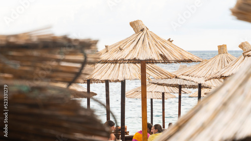 straw beach umbrellas on the shores of the salt sea in a tourist country at the height of the beach season. Umbrellas from the sun