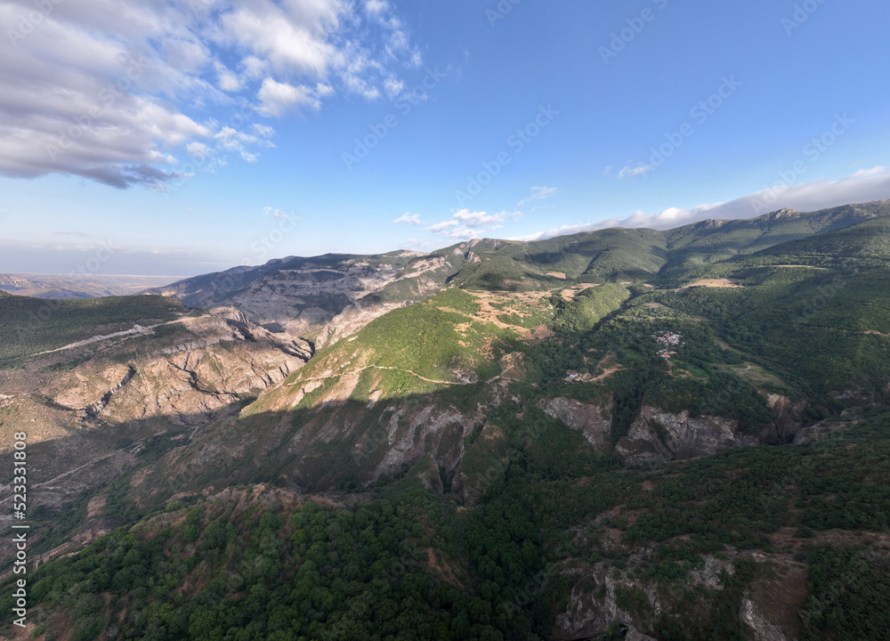 panoramic views of ancient temples and buildings in picturesque places in a gorge in the mountains of Armenia taken from a drone