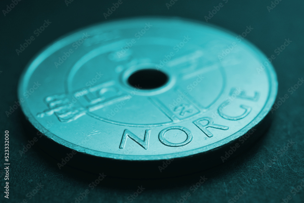 Translation: Norway. 1 Norwegian krone coin close up. National currency of Norway. Teal tinted money background for news about economy or finance. Loan and credit. Tax and inflation. Macro Translation: Norway. 1 Norwegian krone coin close up. National currency of Norway. Teal tinted money background for news about economy or finance. Loan and credit. Tax and inflation. Macro