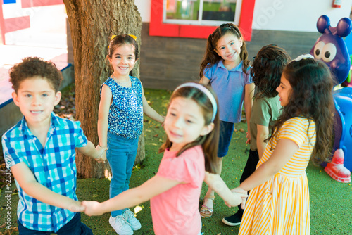 Happy little children forming a circle and playing a game