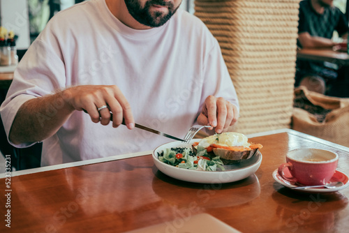 young handsome beard man eating avocado toast in cafe, handsome beard man hair, brutal macho, dine in the restaurant, eating delicious served hot dish, Italian pasta, spices, fine dining, europe, food