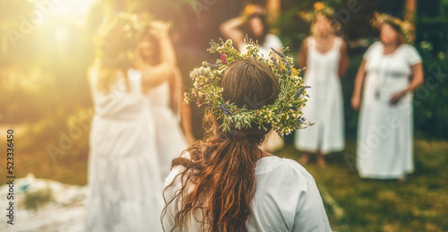 Canvastavla Women in flower wreath on sunny meadow, Floral crown, symbol of summer solstice