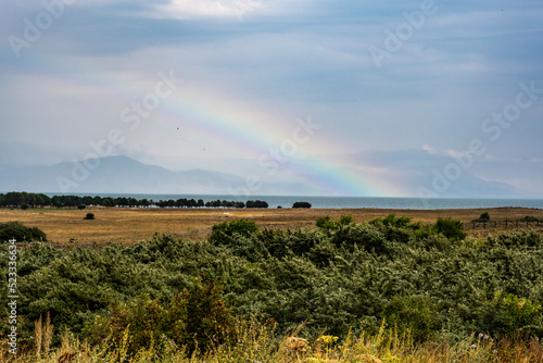 rainbow after the rain against the backdrop of the landscape of mountains and lake Sevan in Armenia