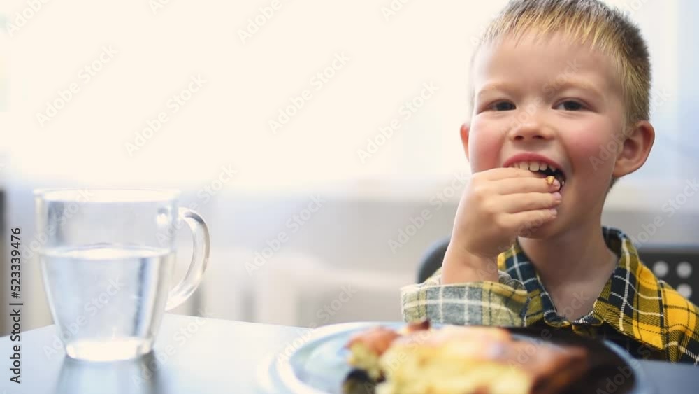 Cute boy eating food in the kitchen Cute boy eating food in the kitchen