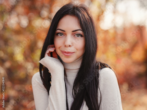 Beautiful young brunette spends her free time in the autumn forest