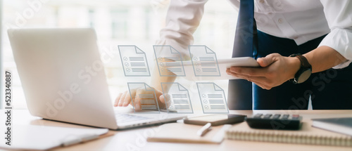 Businessman checking electronic document on a digital document on a virtual laptop computer screen,Paperless workplace idea, e-signing, electronic signature, document management.