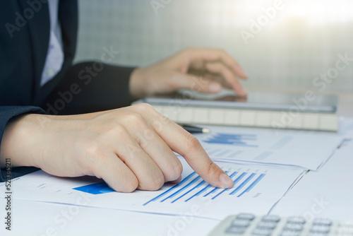 Close-up hand business woman  analyzing chart and graph showing changes on the market.