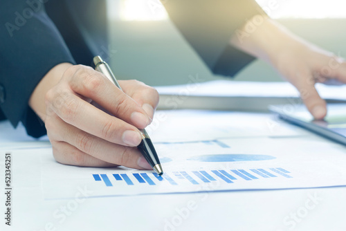 Woman arm holding silver pen point in Marketing financial graph solving. Situation examination at board council sale adviser job stock exchange market profit.