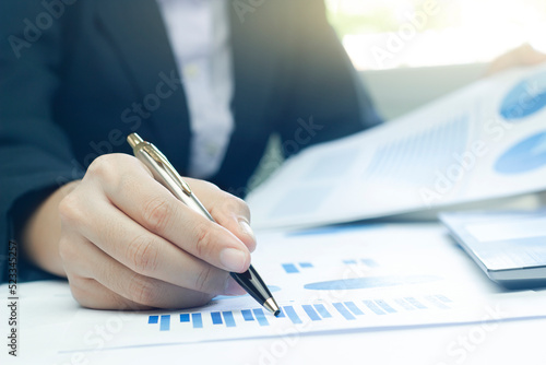 Woman arm holding silver pen point in Marketing financial graph solving. Situation examination at board council sale adviser job stock exchange market profit.