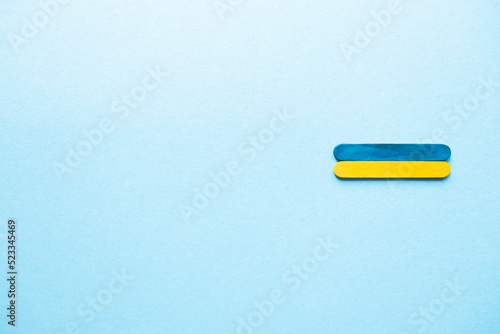 Blue and yellow wooden sticks. Flag of Ukraine on a blue background, free space