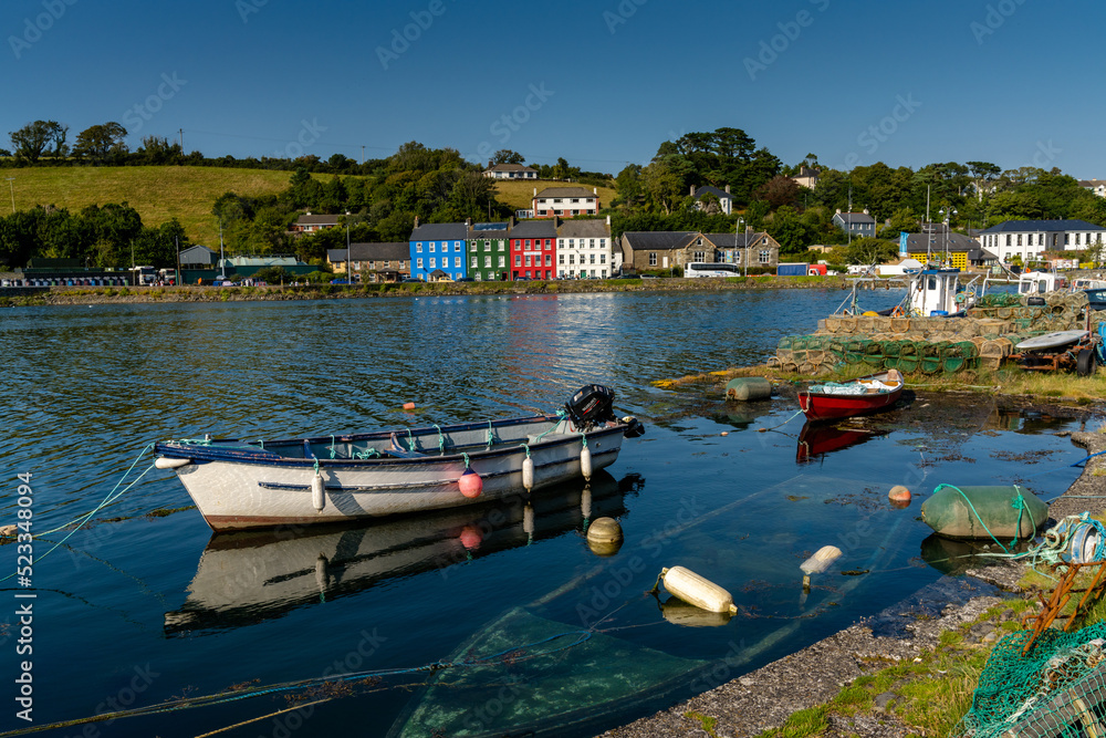 small wooden rowboats and fishing nets and crab traps in Bantry Bay withe downtown Bantry in the background