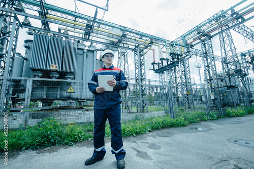 An energy engineer inspects the modern equipment of an electrical substation before commissioning. Energy and industry. Scheduled repair of electrical equipment. © Andrii