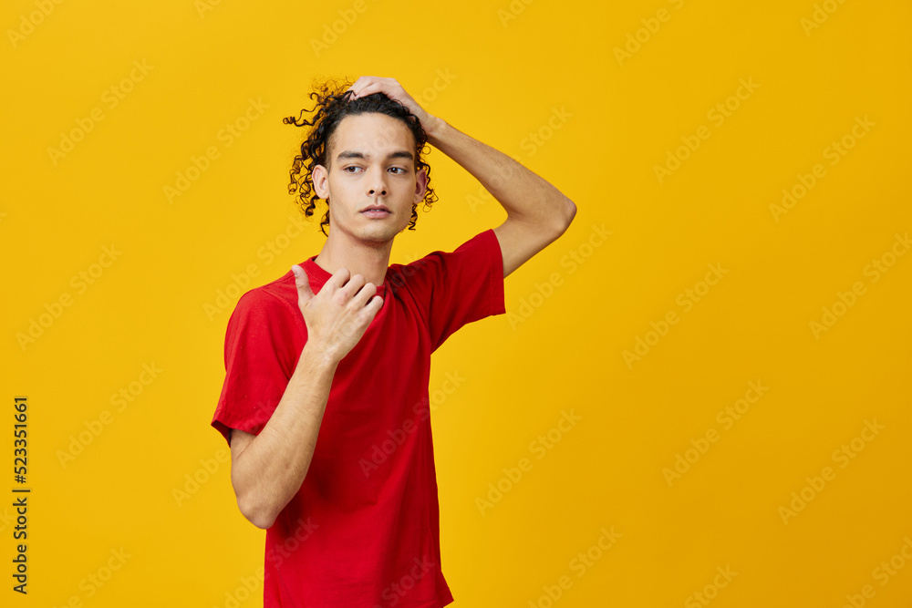 Pensive funny Caucasian young man in red t-shirt point at copy space posing isolated on over yellow studio background. The best offer with free place for advertising. Emotions for everyday concept Pensive funny Caucasian young man in red t-shirt point at copy space posing isolated on over yellow studio background. The best offer with free place for advertising. Emotions for everyday concept