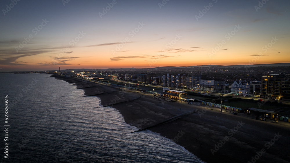 Brighton beach and evening lights of the town, Brighton and Hove, East Sussex, UK
