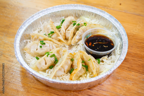 Asian Dumplings or Potstickers with soy sauce in Aluminium Foil Container.