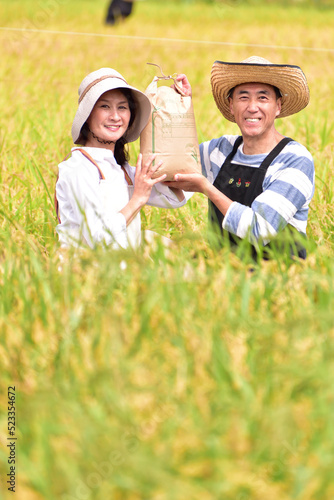 稲穂　収穫　実り　米袋　田園　シニア夫婦