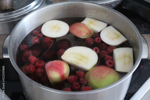 Compote of apples and berries in a saucepan on the hob.