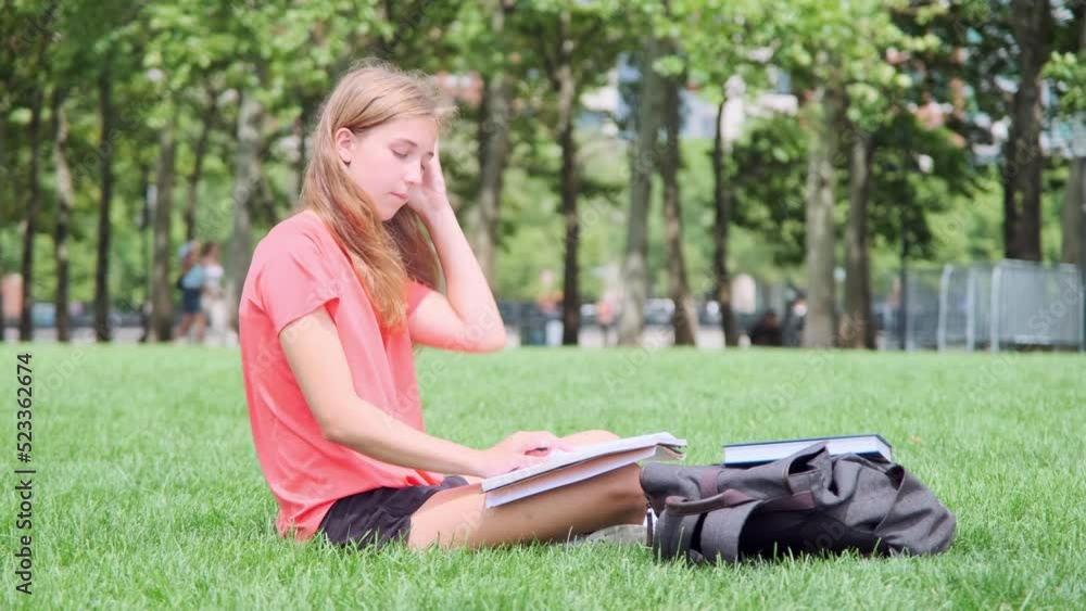 Girl in orange shirt Reading Book on the grass in Summer Girl in orange shirt Reading Book on the grass in Summer