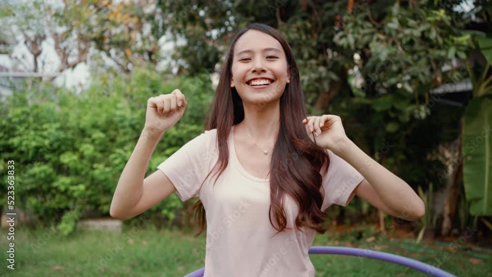 Asian beautiful young woman doing cardio workout in garden at house. Happy attractive girl enjoy free leisure activity exercise rotating hula hoop to lose weight for healthcare and well being at home. Asian beautiful young woman doing cardio workout in garden at house. Happy attractive girl enjoy free leisure activity exercise rotating hula hoop to lose weight for healthcare and well being at home.