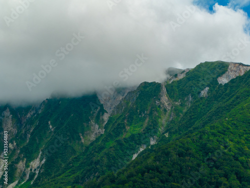 Green slopes and rugged cliffs near peak of Mt. Daisen in Tottori, Japan