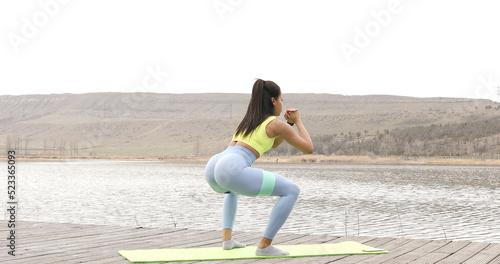 Fit woman doing exercise with resistance band. Beautiful butt, fitness girl working out. Athletic girl doing exercise for glute with resistance band. Fitness woman workout.