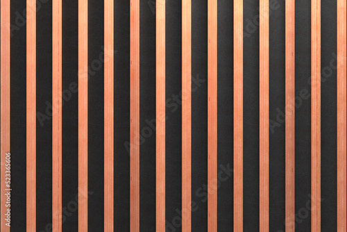 A wooden lamella wall in the color of natural wood with a pattern of wall panels in the background.