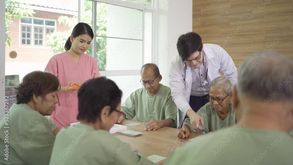 Portrait of happy group of old elderly Asian patient or pensioner people with a nurse and doctor playing games in nursing home. Senior lifestyle activity recreation. Retirement community. Health care Portrait of happy group of old elderly Asian patient or pensioner people with a nurse and doctor playing games in nursing home. Senior lifestyle activity recreation. Retirement community. Health care