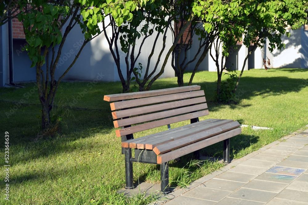 Macro photo of a wooden bench. Texture background urban landscape bench with wrought iron legs. wooden garden bench in the city on the background of nature Macro photo of a wooden bench. Texture background urban landscape bench with wrought iron legs. wooden garden bench in the city on the background of nature