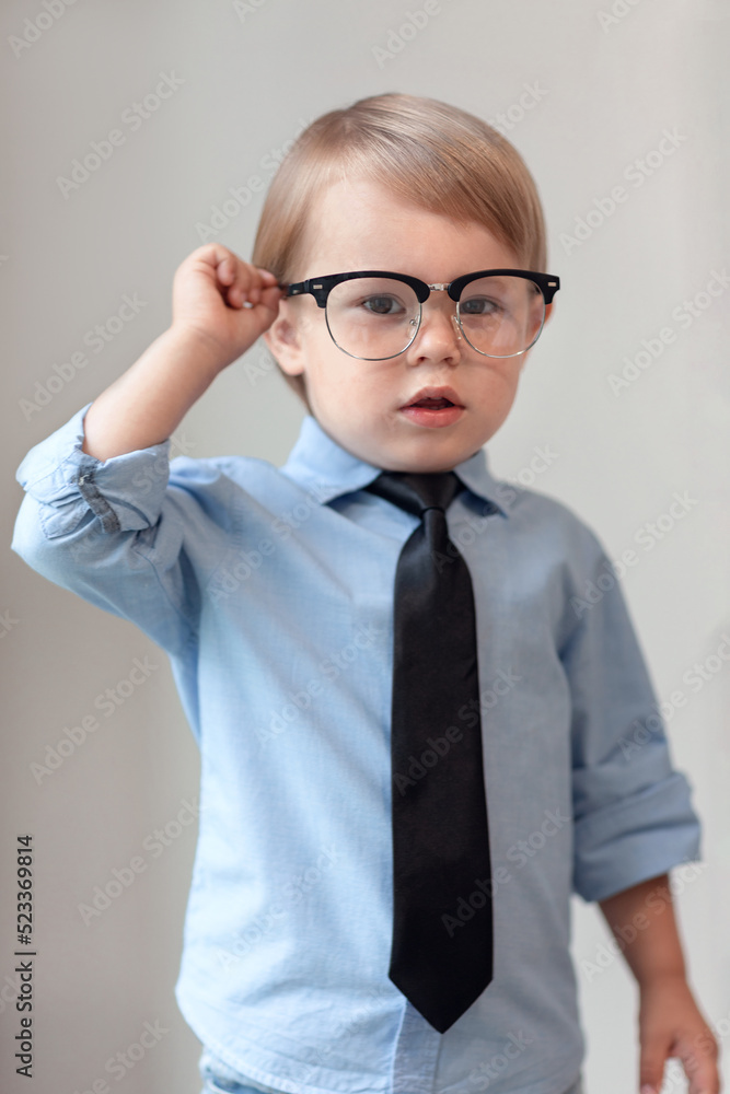 serious smart kid in glasses and tie, boy isolated, little genius, education and success concept
