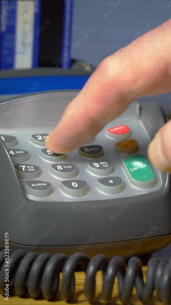 Vertical video social media format – Closeup of a defocused payment card in a chip and pin reader, with a finger keying in a PIN number, then pressing enter to complete the transaction. Vertical video social media format – Closeup of a defocused payment card in a chip and pin reader, with a finger keying in a PIN number, then pressing enter to complete the transaction.