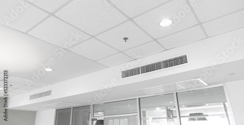 Ceiling mounted cassette type air conditioner and modern lamp light on white ceiling. duct air conditioner for home or office