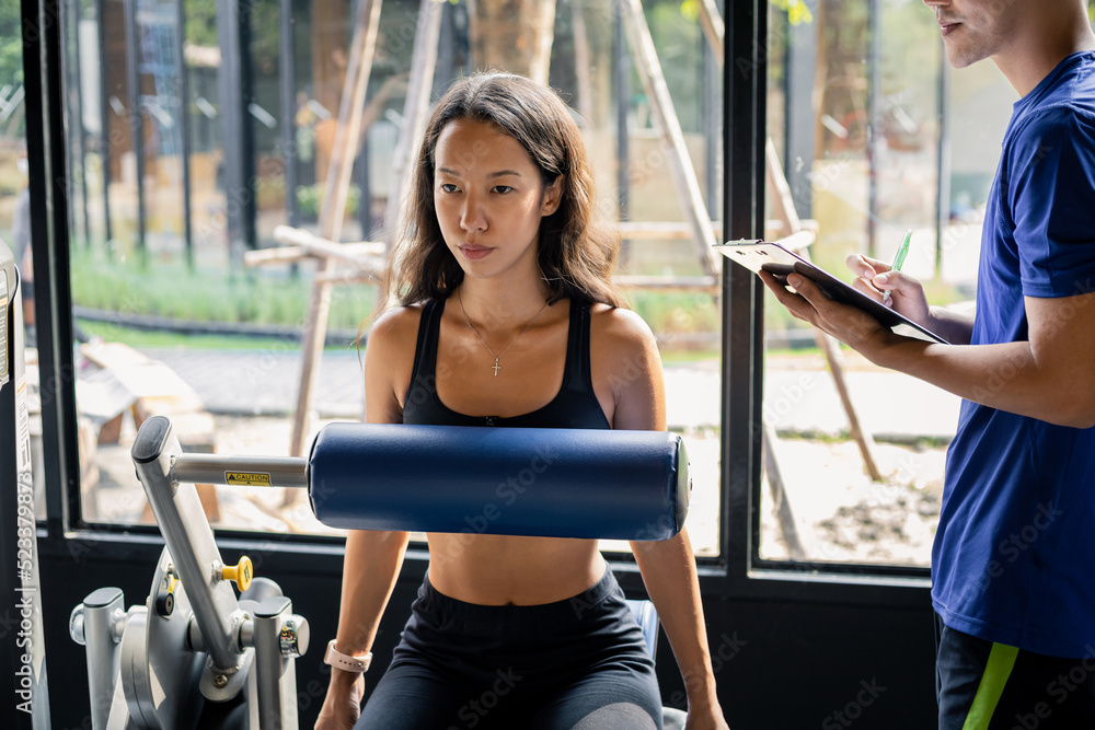 Fototapeta premium Young woman exercises on an exercise machine.