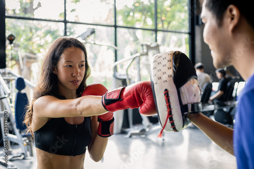Young woman doing boxing training with her coach.