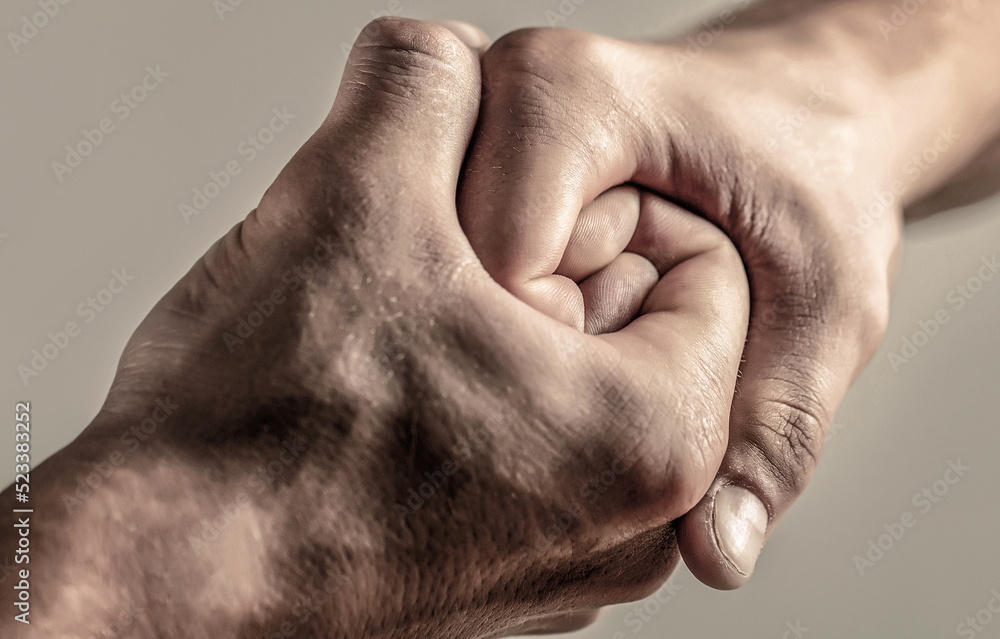 Fototapeta premium Male hand united in handshake. Man help hands, guardianship, protection. Friendly handshake, friends greeting. Rescue, helping hand