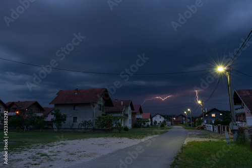 Thunderstorm and dark clouds above suburbs at dusk, bad weather