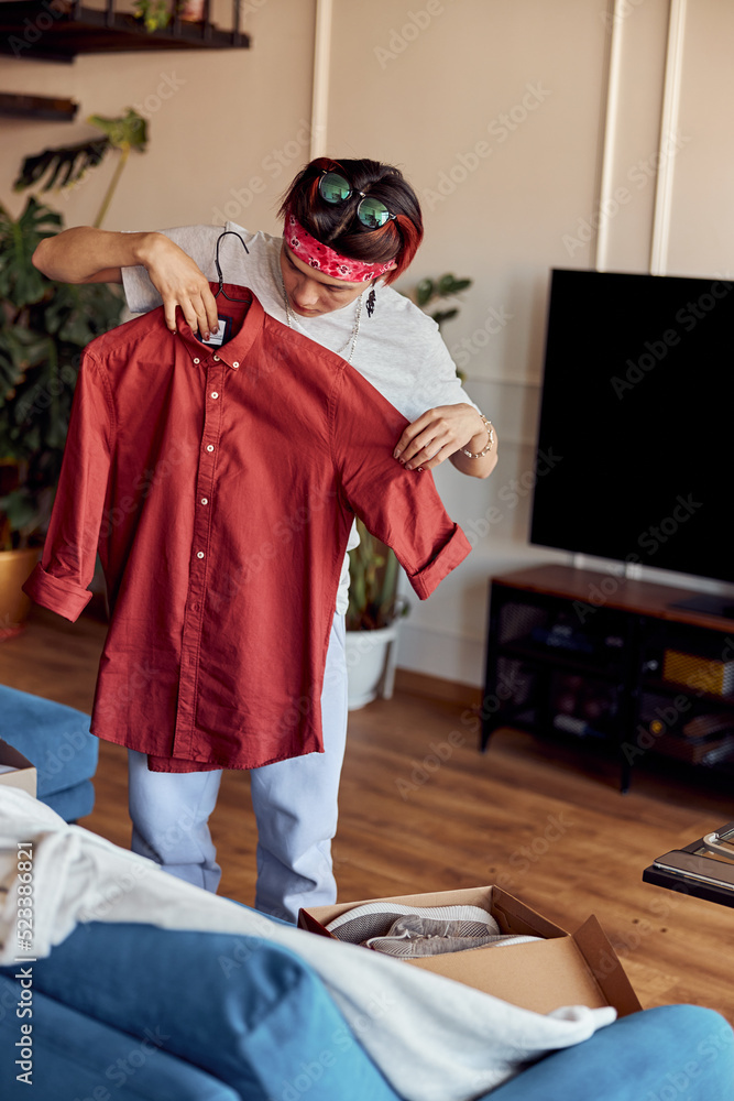 Asian guy reviewing his online purchases at home