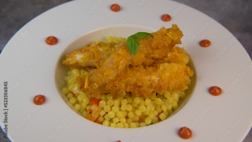 Recipe for chicken tenders with corn flakes and Italian Piombo pasta risotto and peppers on turntable. High quality video Recipe for chicken tenders with corn flakes and Italian Piombo pasta risotto and peppers on turntable. High quality video