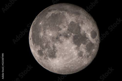 Extreme close up with telephoto lens of full moon in cloudless sky
