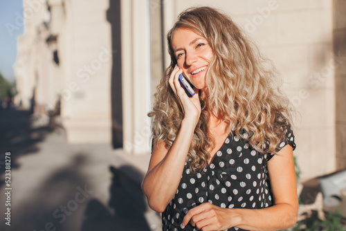 Woman walks down the central City Street and uses her Phone