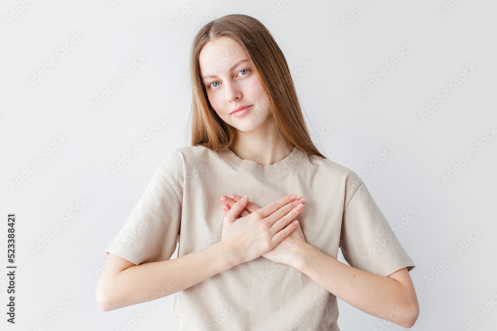 hopeful young woman holding hands on chest