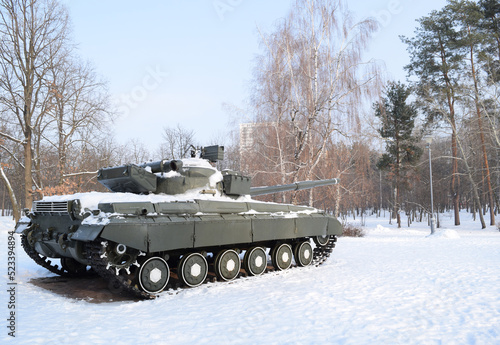 A large military tank stands in a winter forest. tank in the snow. Tank in winter. Military equipment