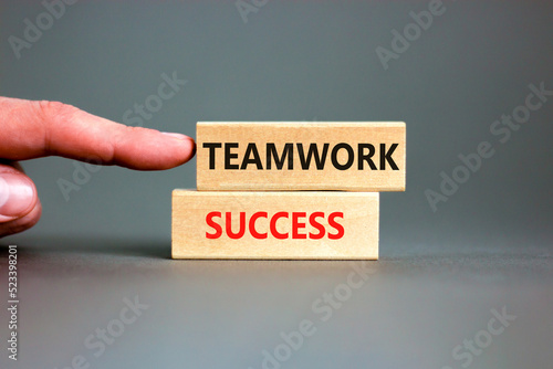 Teamwork success symbol. Concept words Teamwork success on wooden blocks on a beautiful grey table grey background. Businessman hand. Business and teamwork success concept. Copy space.