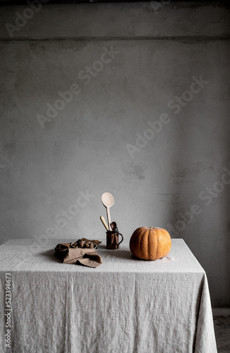 Pumpkin season kitchen table set up with fresh pumpkin from the market and cooking utensils.
